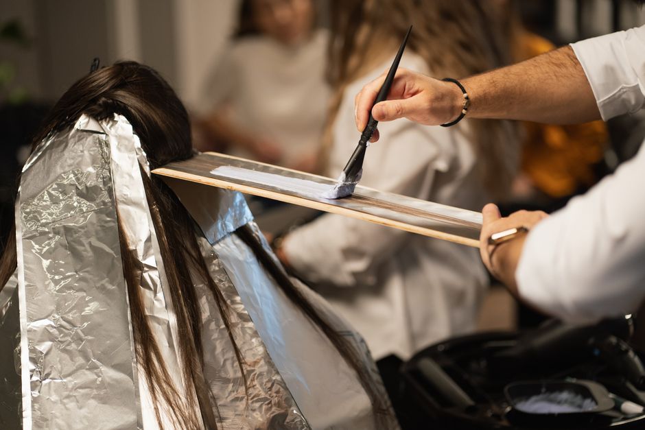 Hair colorist applying color to a client